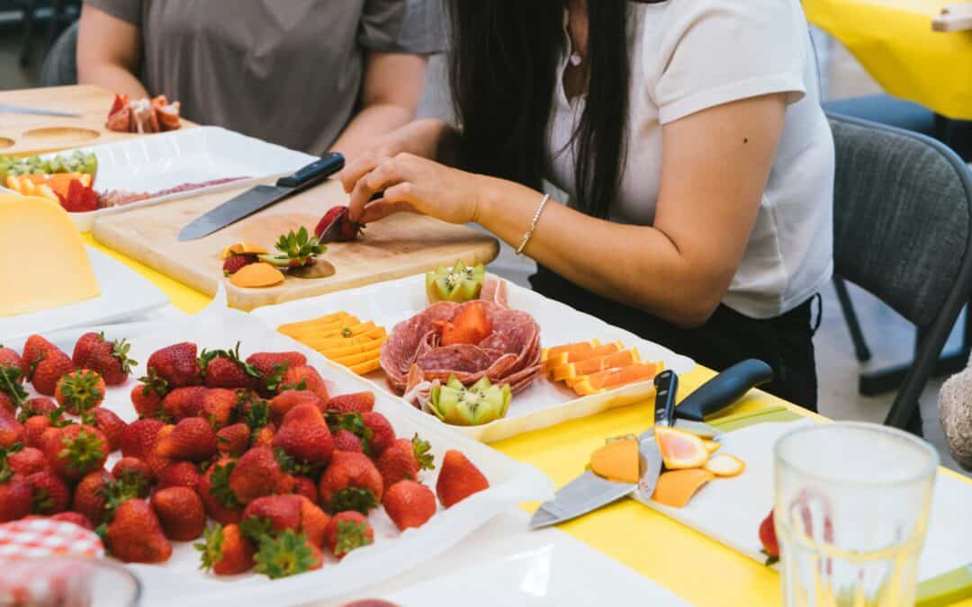 Young people preparing healthy food on chopping boards